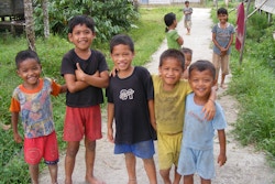 Fem gutter som står ved siden av hverandre og smiler